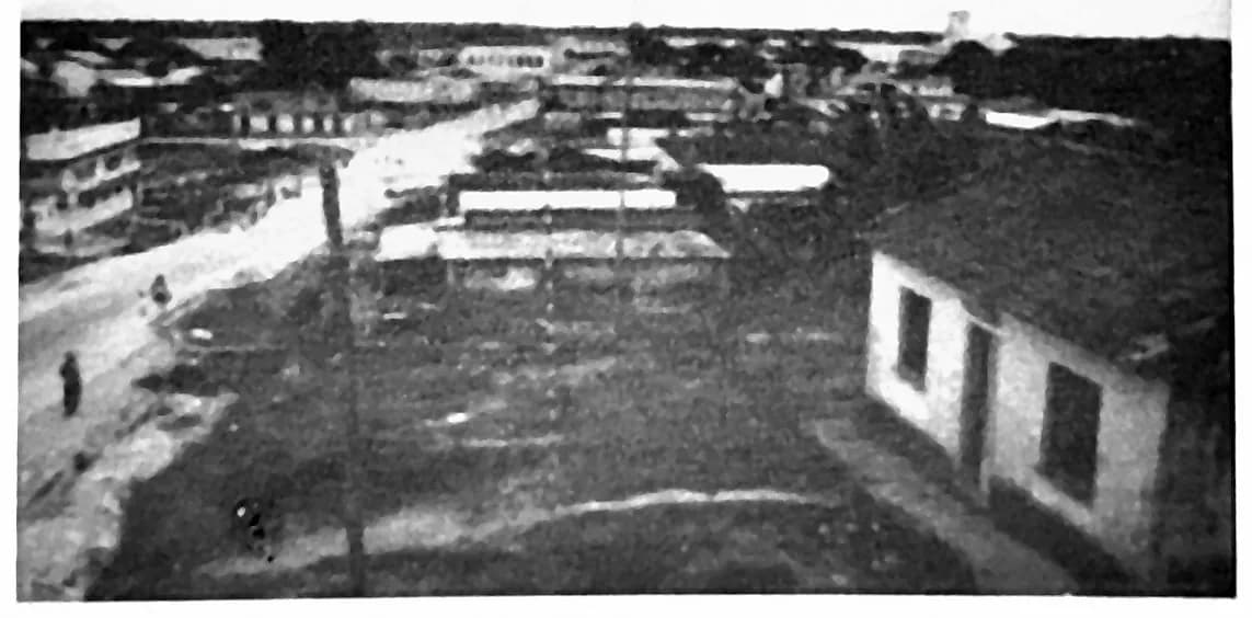 Fotografia antiga da rua Olavo Bilac, de casario térreo contínuo e rua de terra
