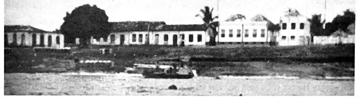 Fotografia de 1940 da orla de Tefé vista do lago, com casario baixo de telhado de duas águas e uma embarcação encalhada na praia