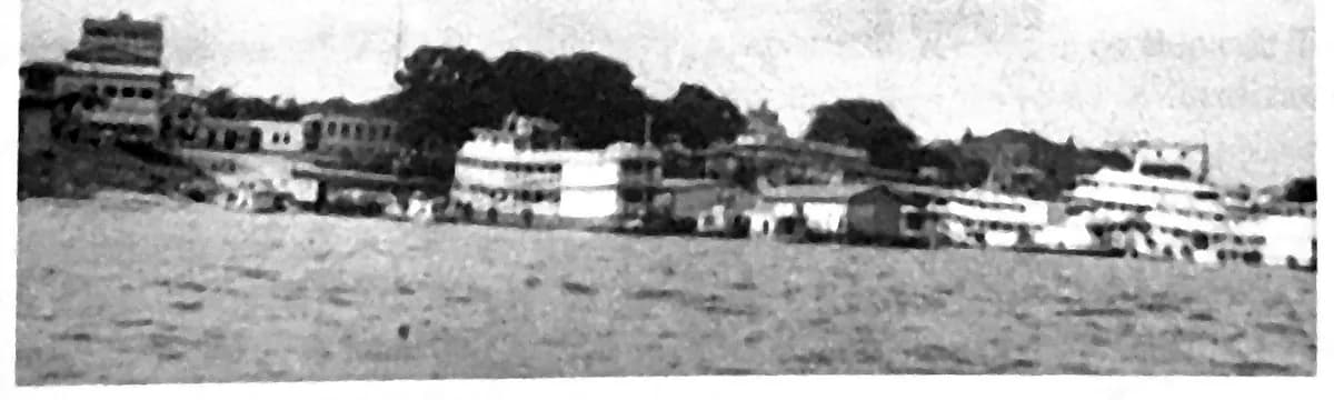 Fotografia de 2003 da orla de Tefé, com prédios de vários pavimentos e embarcações de recreio e de comércio fluvial atracadas